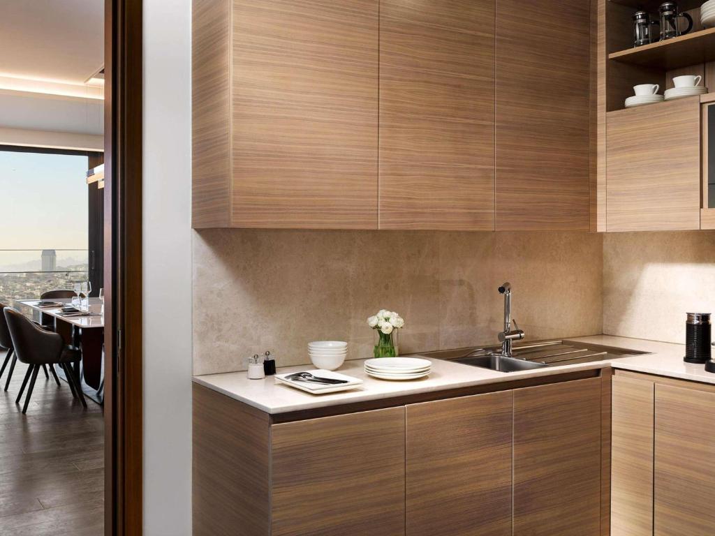 a kitchen with wooden cabinets and a dining table at Fairmont Quasar Istanbul Hotel in Istanbul