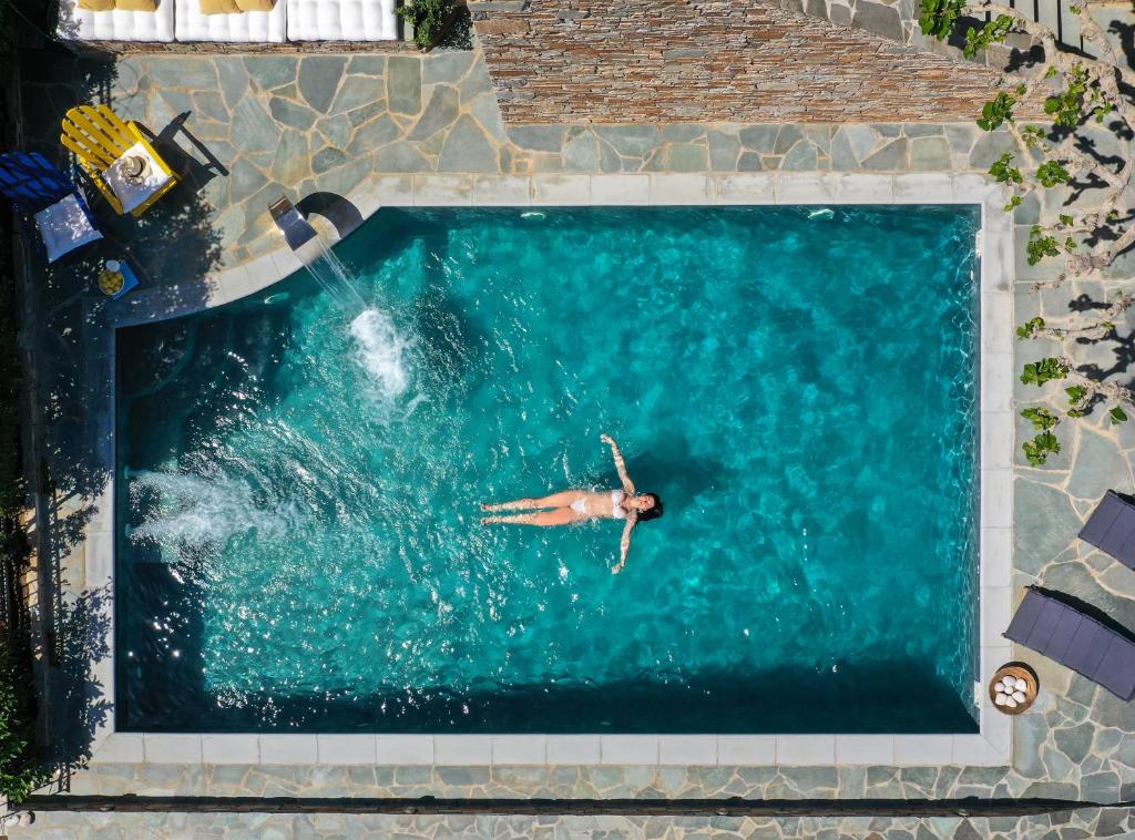 a person swimming in a swimming pool at Astraea Villa in Karistos