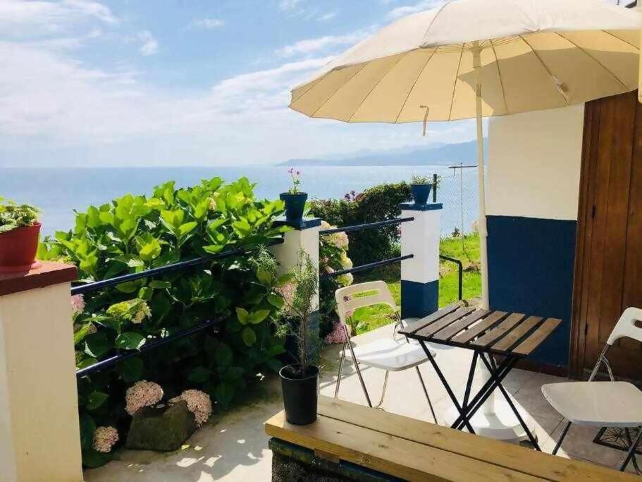 a patio with an umbrella and a table and chairs at La casina de La Fragua in Lastres