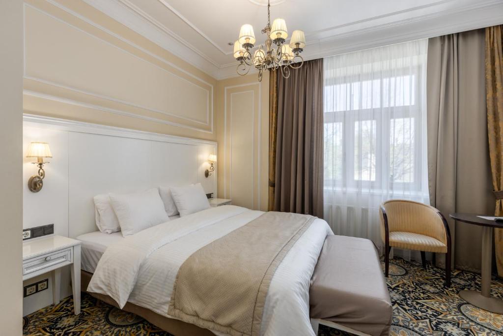 a bedroom with a bed and a desk and a window at Gertrude Hotel self check-in in Riga