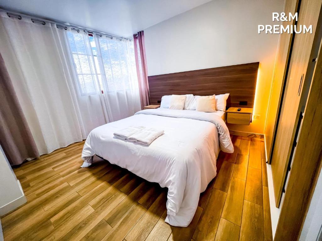 a bedroom with a large bed with a wooden floor at Estancia Exclusiva R&M in Pelileo