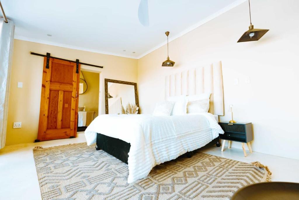 a bedroom with a white bed and a wooden door at Best for last resorts in Kalkheuvel
