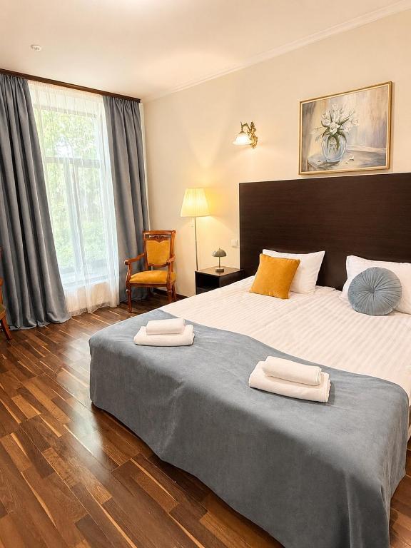 a bedroom with a large bed with two towels on it at Alex Hotel in Odesa
