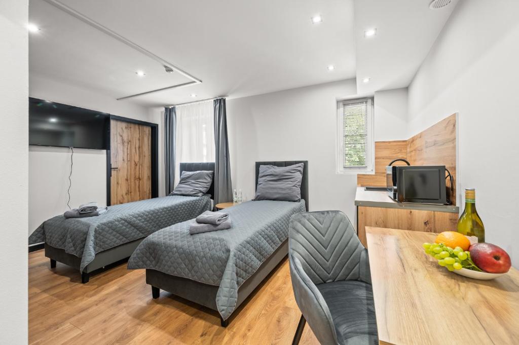 a living room with two beds and a tv at Central Platinum Apartments 10 in Rybnik