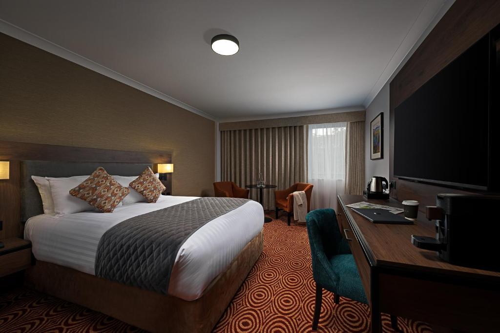 a hotel room with a bed and a desk at Great National South Court Hotel in Limerick