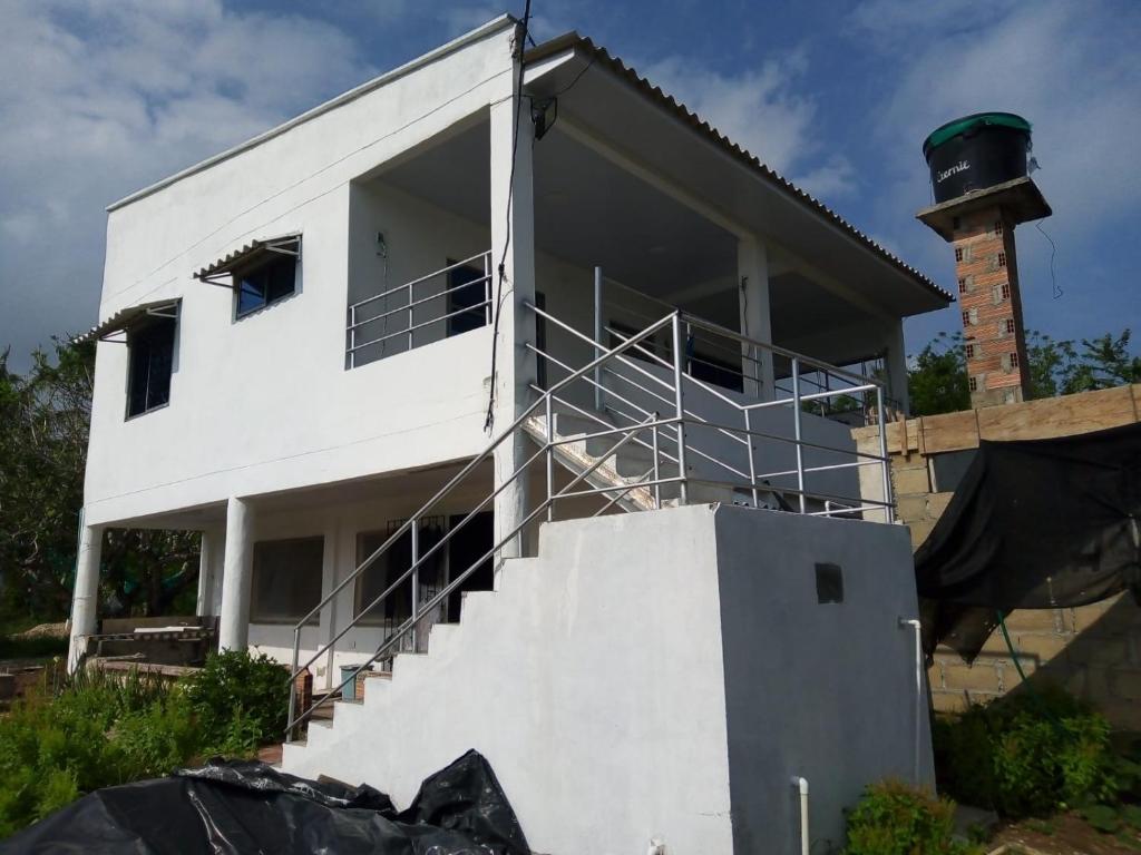 a white house with a staircase in front of it at Cabaña MAR PLAYA in San Antero