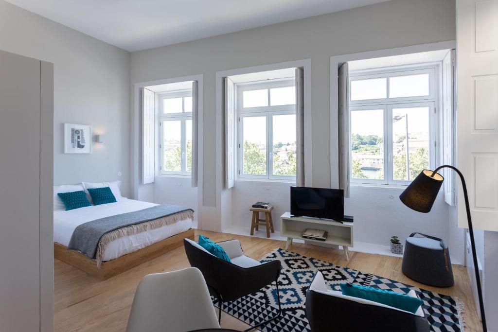 una camera con letto, TV e finestre di Seventyset Flats - Porto Historical Center a Porto