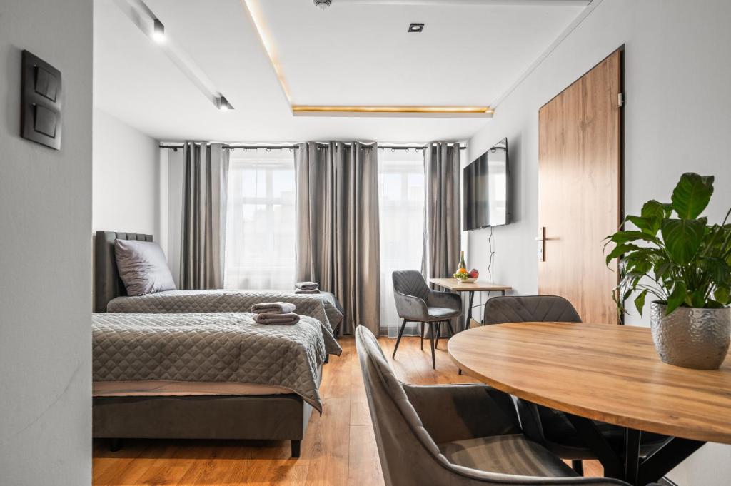 a bedroom with two beds and a table and chairs at Central Platinum Apartments 12 in Rybnik