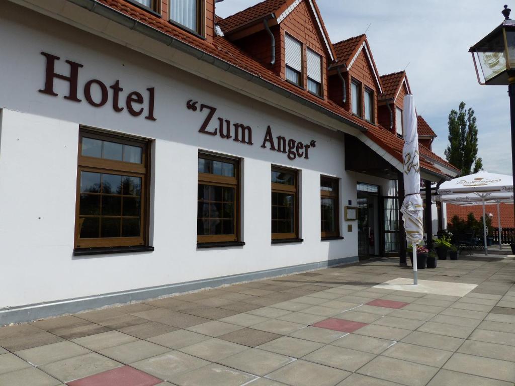 ein Hotel zermatt mit einem Schild an der Seite eines Gebäudes in der Unterkunft Hotel Zum Anger in Neukirchen-Pleiße