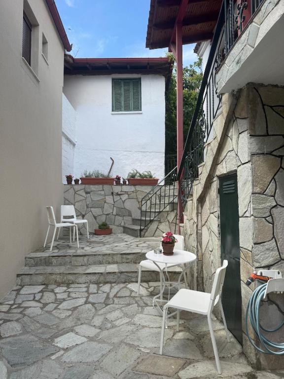 a patio with chairs and a table and a building at The Village Studio AVLI Upper Vrasna in Nea Vrasna