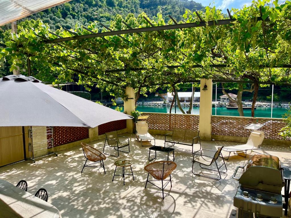 a patio with a table and chairs and an umbrella at Appartement terrasse vue lac in Breil-sur-Roya