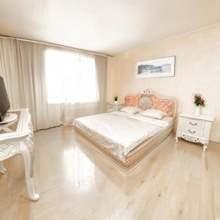 a bedroom with a bed and a desk and a television at Кардиоцентр in Dnipro