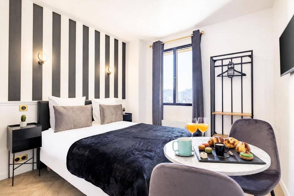 a hotel room with a bed and a tray of food at Hôtel Mijo's in Fontenay-sous-Bois