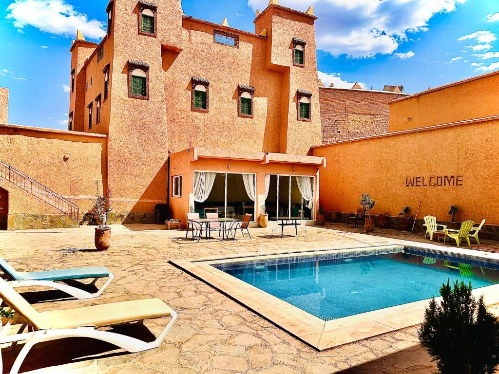 a swimming pool in front of a building at Kasbah ben hamou in Nkob