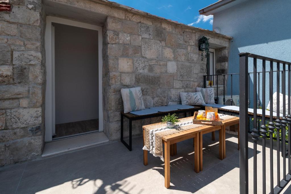a patio with a table and a bench on a balcony at Balatura House in Trogir