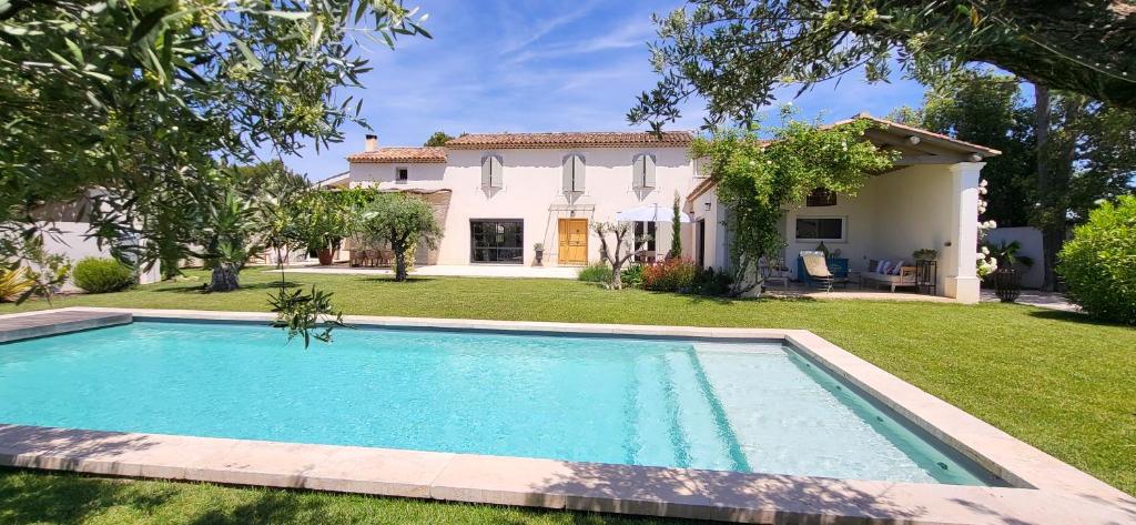a large swimming pool in front of a house at La Cigale dans l'Olivier in Vernègues