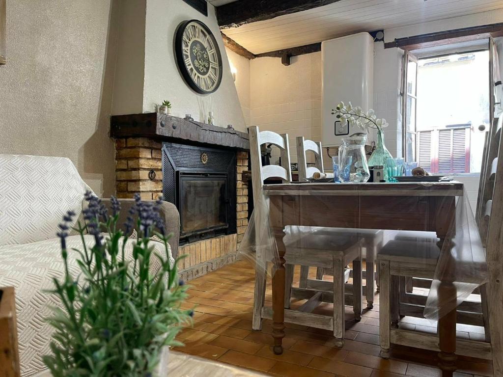 a living room with a table and a fireplace at Studio de charme in Breil-sur-Roya