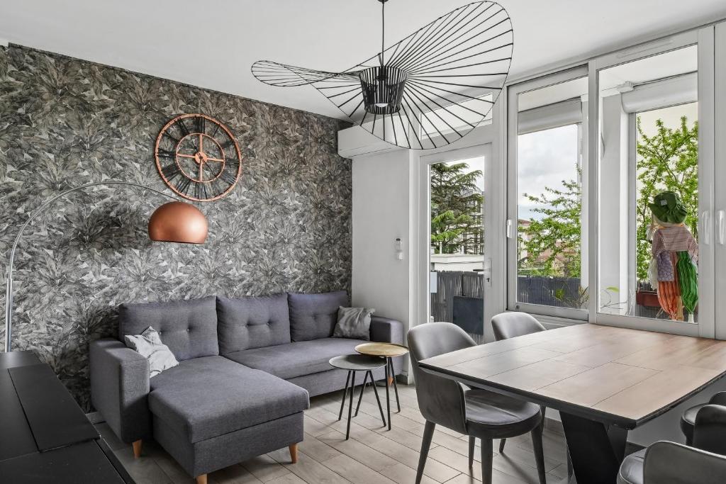 a living room with a couch and a table at Pop Eurexpo - Parking Privé, Terrasse, Climatisation in Bron