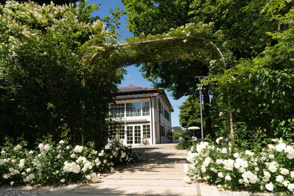 a garden with white flowers in front of a building at Maison Chambre et Jardin in San Martino in Rio