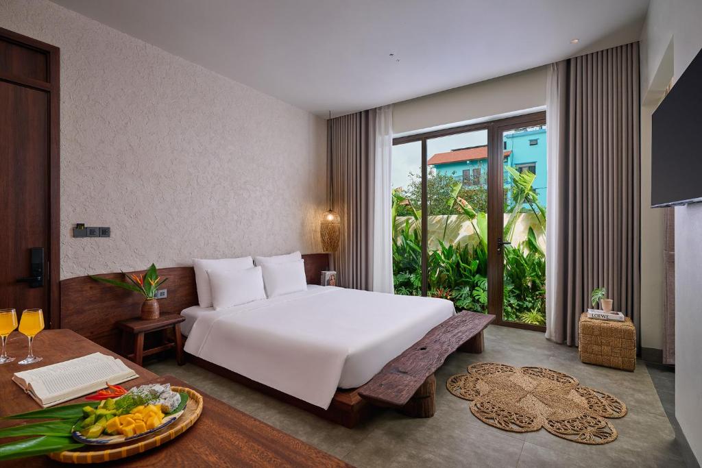 a bedroom with a bed and a table with a tray of fruit at ArtLua Boutique Hotel Tam Coc in Văn Lâm