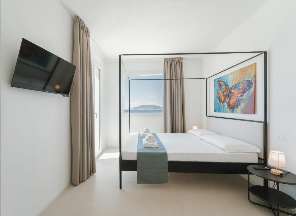 a bedroom with a bed and a tv and a window at Almarè Affittacamere in Favignana