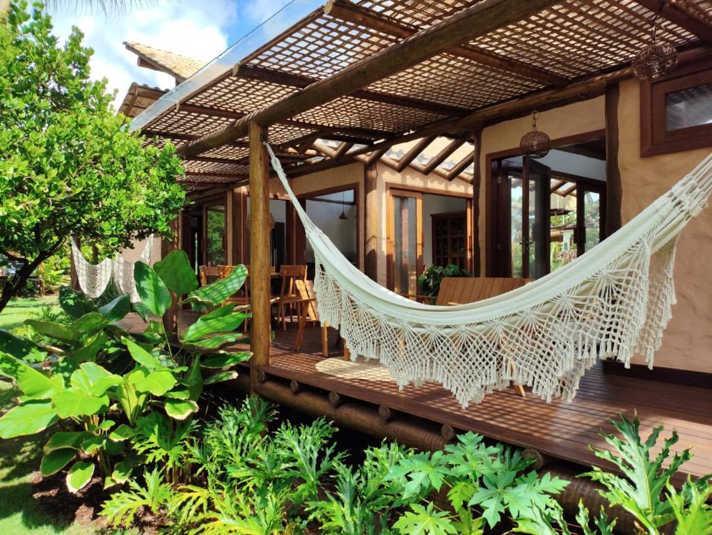 a hammock on the porch of a house at Vida Cajuína Maraú in Marau