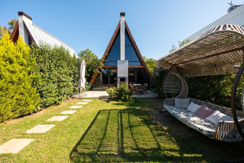 a garden with a house with a couch in the yard at Begonvil Gümüşlük in Gümüşlük