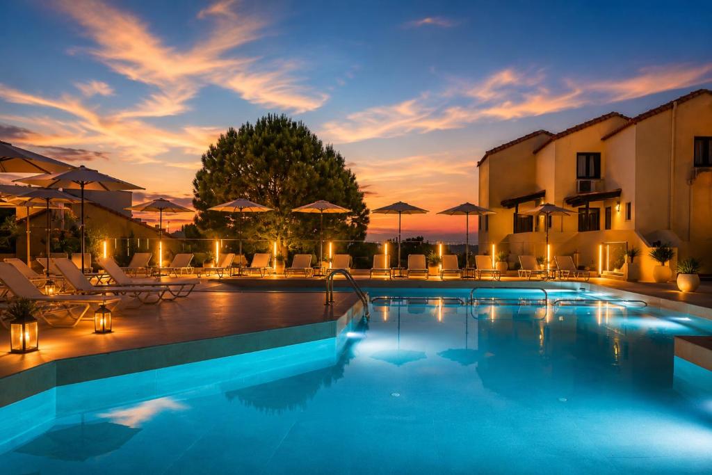 a pool with chairs and umbrellas at a hotel at Dream Village in Hersonissos
