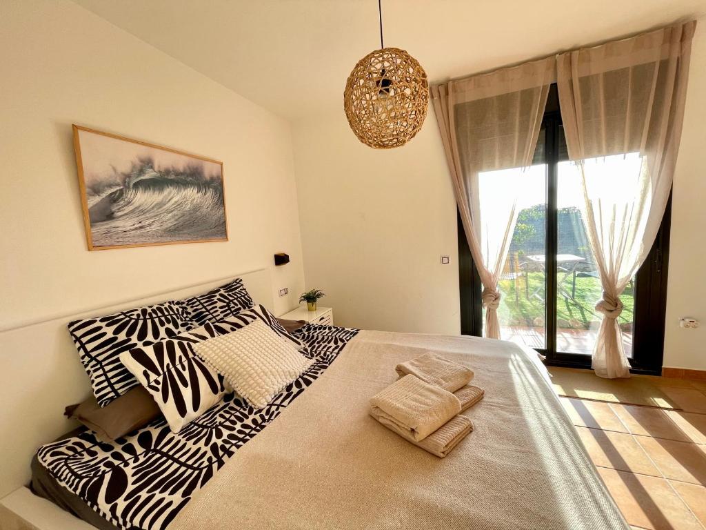 a bedroom with a bed with zebra pillows and a window at El Nido del Sol in La Oliva