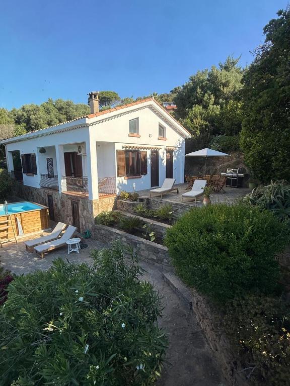 a white house with a patio and a swimming pool at Villa Rosette Ile du levant in Hyères