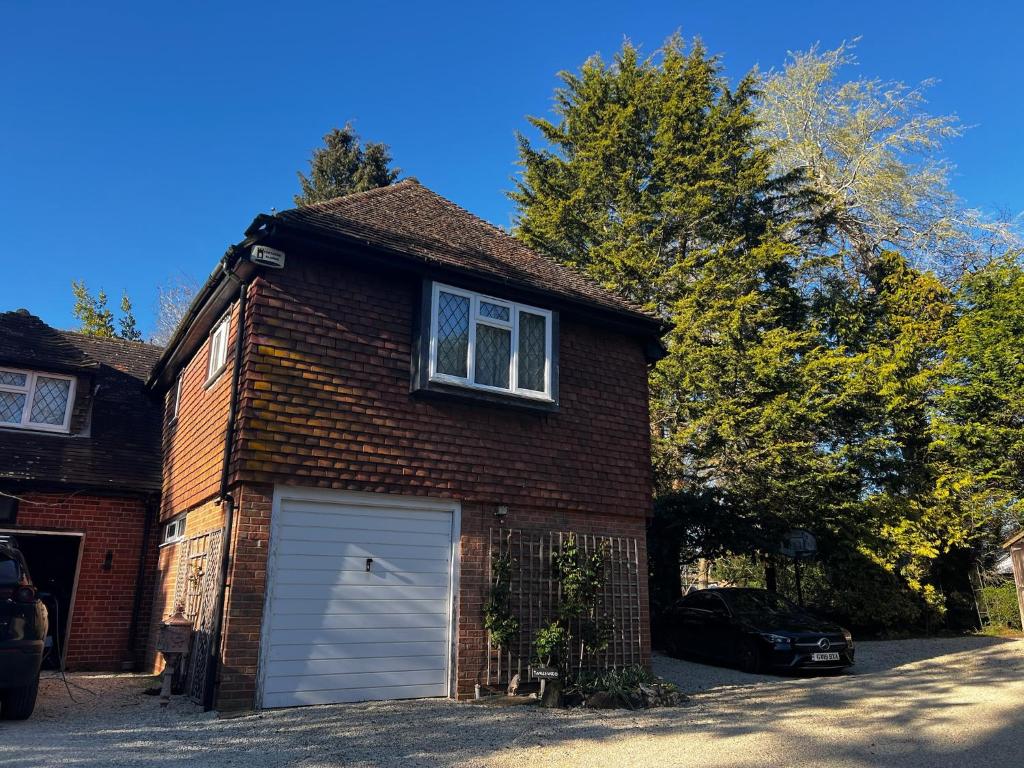 a brown brick house with a white garage at Hidden cottage in Abingdon