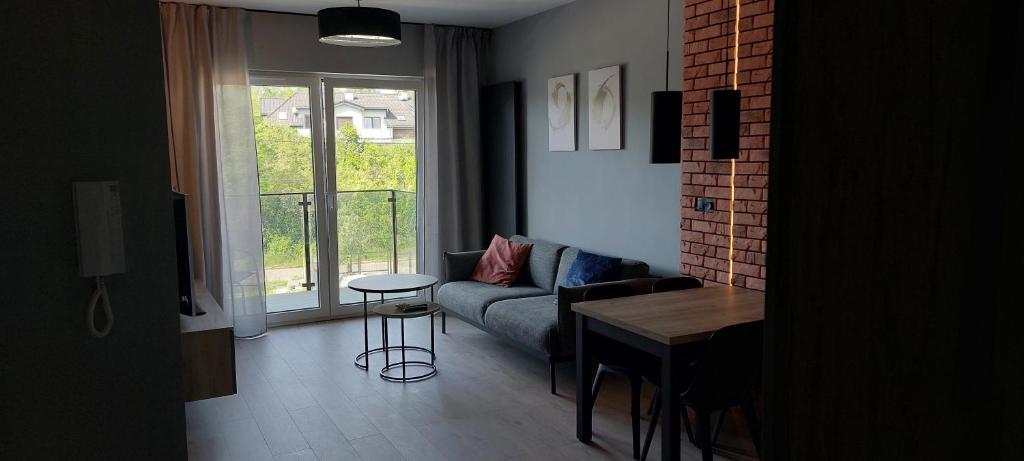 a living room with a couch and a table at Apartament Podjasnogórski Loretańska in Częstochowa