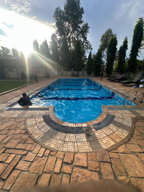 a swimming pool with blue water on a brick ground at Cozy haven in Kampala
