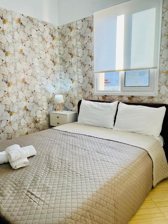 a bedroom with a large bed and a window at Seren Apartment in Vlorë