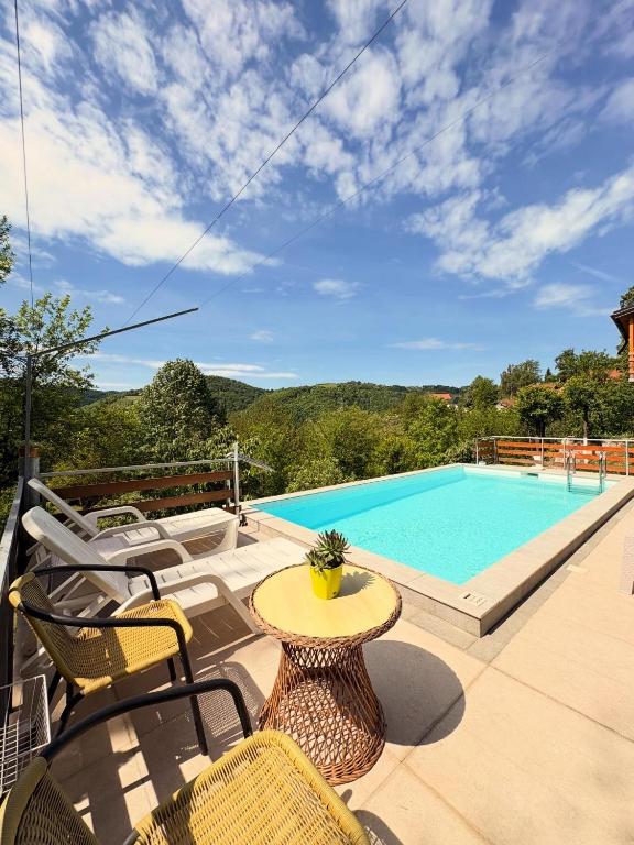 a patio with a table and chairs and a swimming pool at Vikendica Brda in Banja Luka
