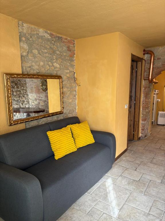 a couch with two yellow pillows in a room at Le Soleil in Casale Marittimo