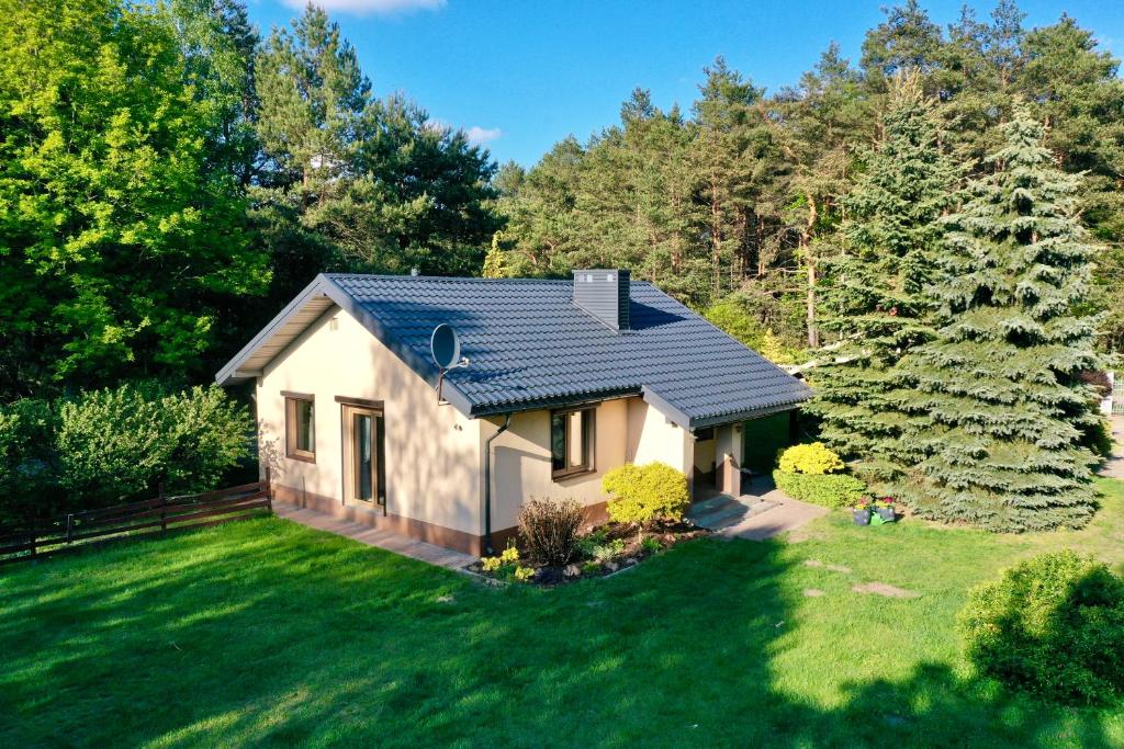 a small white house in the middle of a yard at Leśny Reset in Imielnia