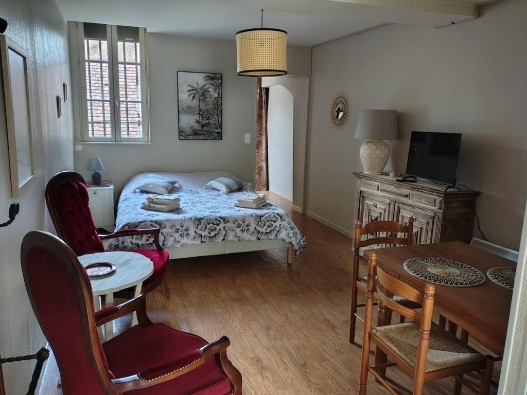 a bedroom with a bed and a table and chairs at Studio chez Jef in Nuits-Saint-Georges