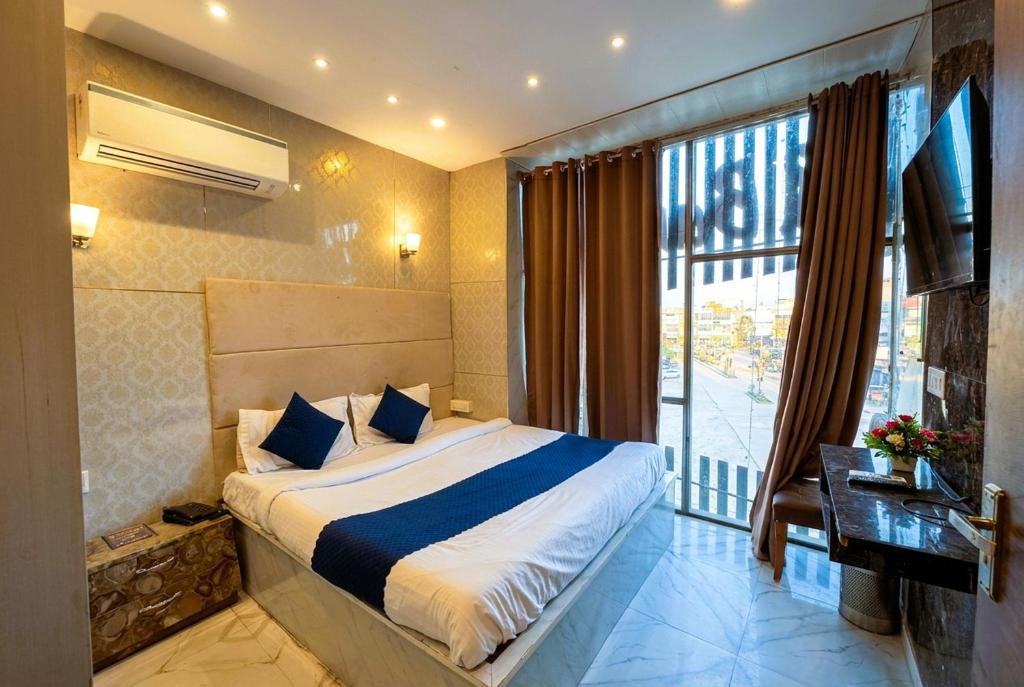 a bedroom with a bed and a large window at Hotel Velvet Dreams Inn & Banquet in Kharar