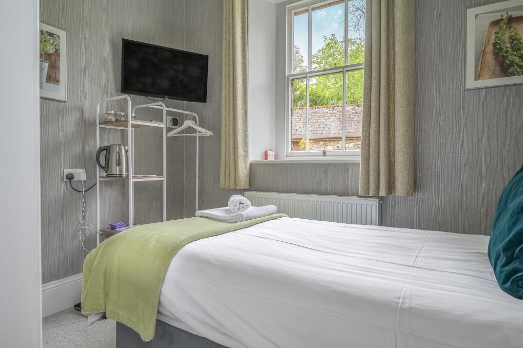 a bedroom with a white bed and a window at The Capsule Room at The Lairbeck in Keswick in Keswick