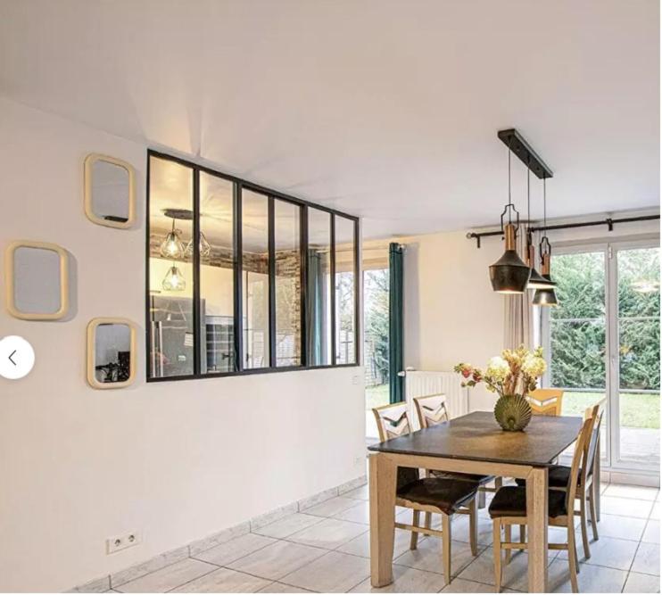 a dining room with a table and some chairs at Villa Near Versailles in Feucherolles
