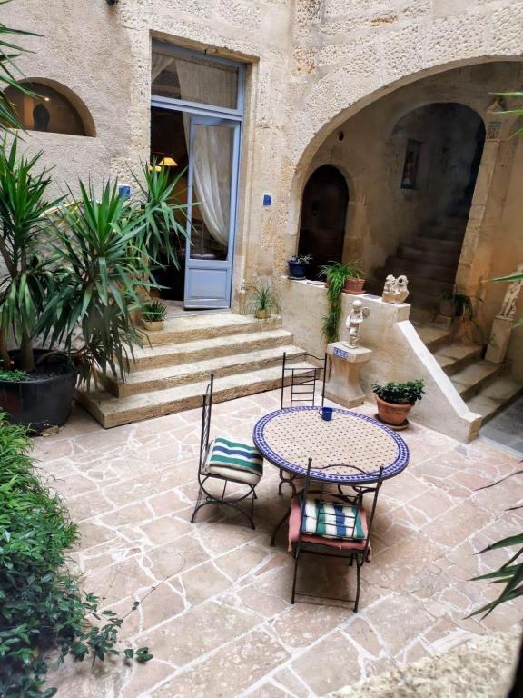 a patio with a table and chairs and a door at Demeure BelPel - Appartement Daurel in Bessan