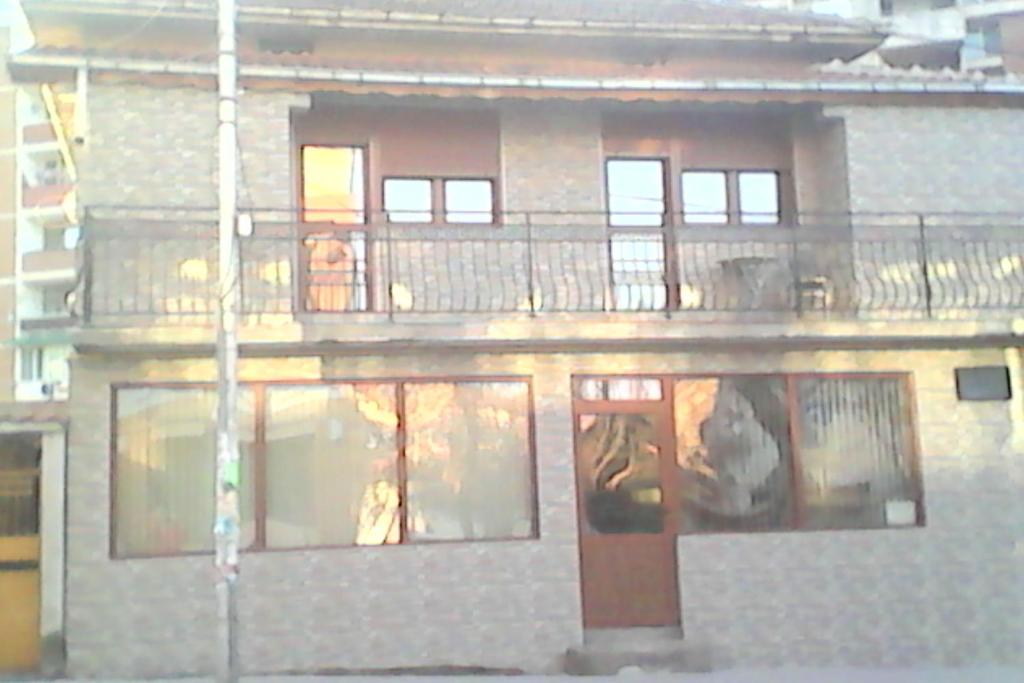 un edificio con un balcón con gente. en Guest House Lili, en Petrich