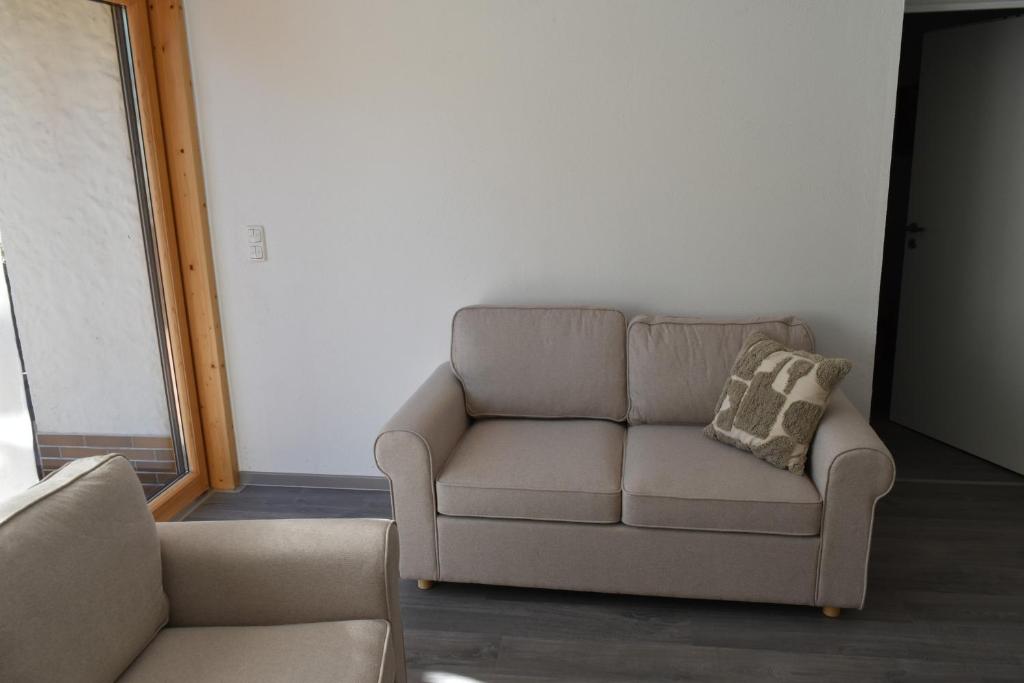 a couch sitting in a living room with a pillow at Ferienwohnung Carlo in Bindlach