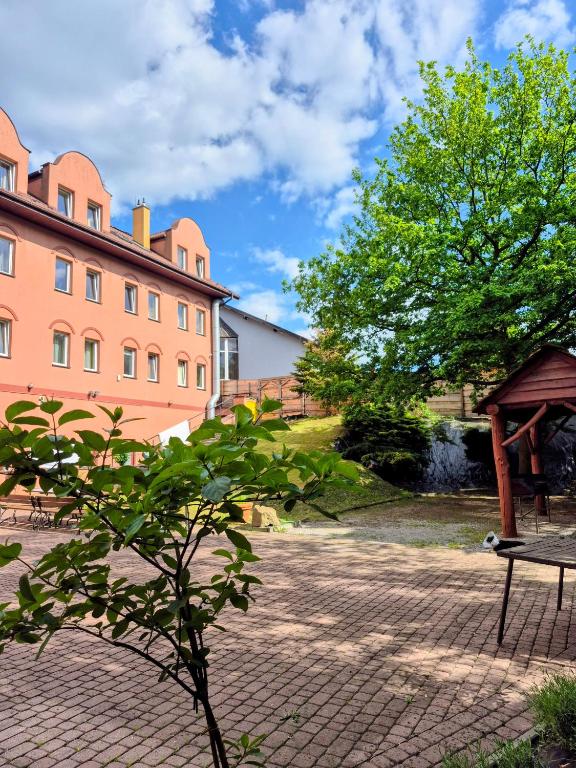 a tree in a courtyard with a building at Salis Resort in Wieliczka