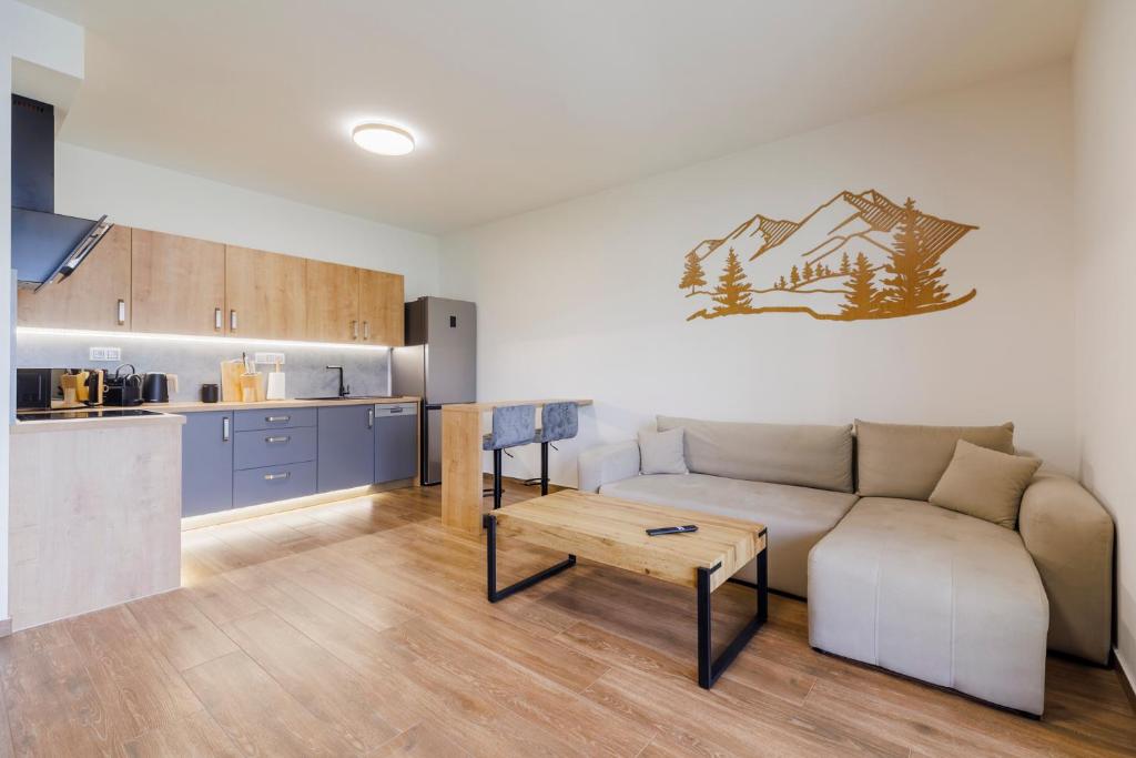 a living room with a couch and a kitchen at Apartmán U mlýnu in Červená Voda