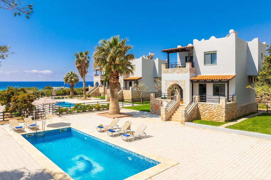 a villa with a swimming pool and the ocean at Spiros Beach Villa in Frangokastello