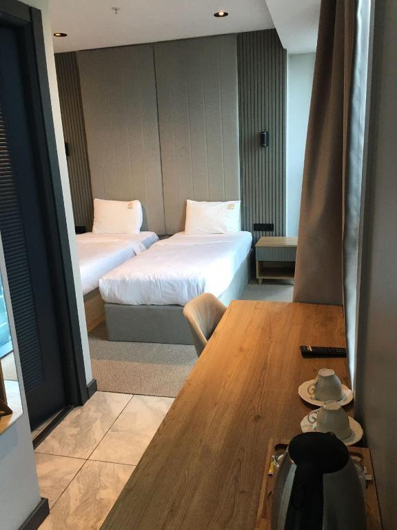 a hotel room with two beds and a table with a hat at SHERLOCK HOMES HOTELS in Istanbul