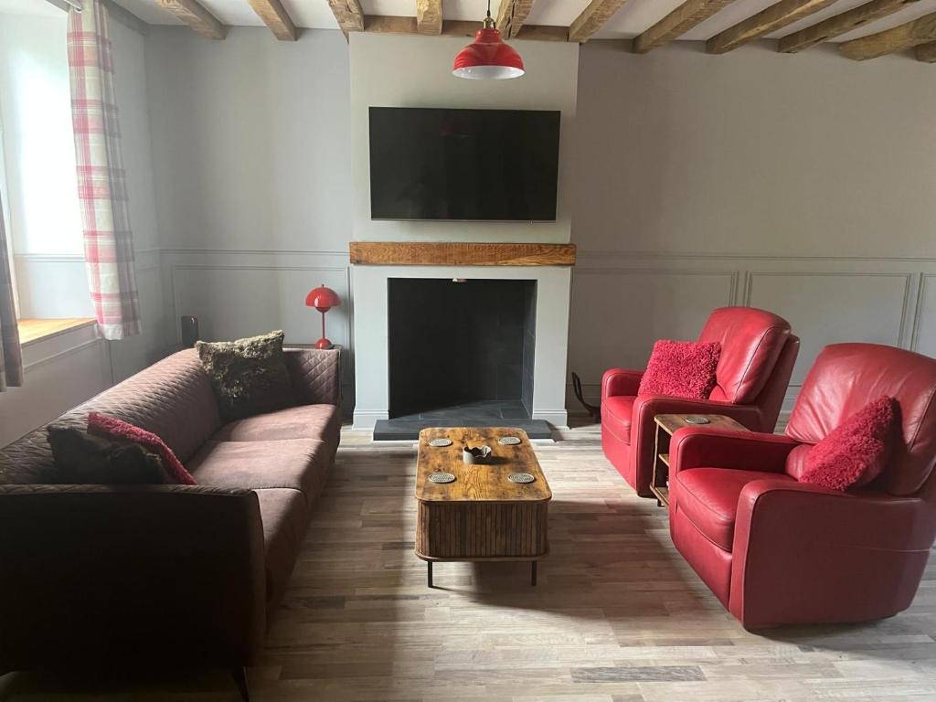a living room with two couches and a fireplace at The Old Post Office Gite -Jouac in Jouac