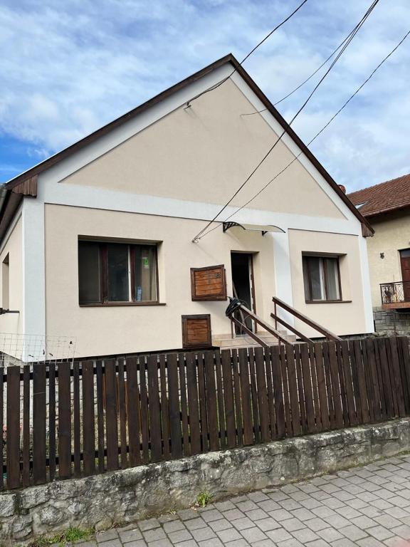 a white house with a fence in front of it at Katalin vendégház felső szint in Visegrád